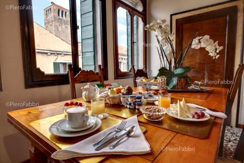 een houten tafel met ontbijtproducten erop bij La Villeggiatura in Venetië