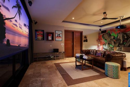 a living room with a couch and a flat screen tv at Villa Baan Saitara in Lamai
