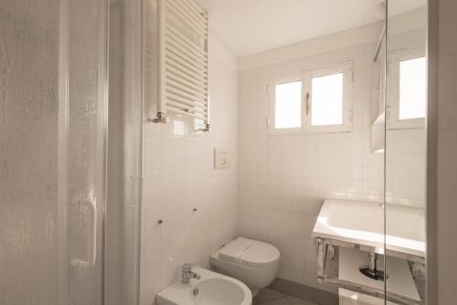 biała łazienka z toaletą i umywalką w obiekcie Pellegrino 75 Double Bedroom w Rzymie