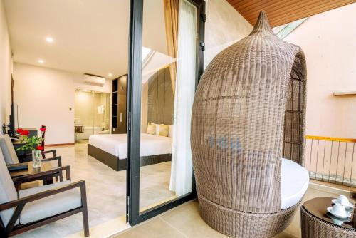 Zimmer mit einem Bett und einem Zimmer mit einer Glastür in der Unterkunft Khong Cam Garden Villas in Hoi An
