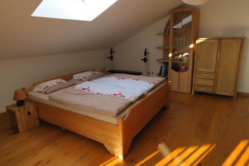 1 dormitorio con cama de madera en una habitación en Ferienwohnung Reiteralmblick - Regina Häusl, en Schneizlreuth
