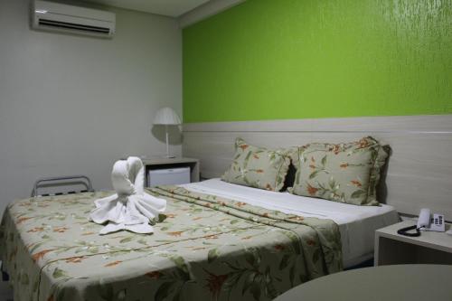 a hotel room with a bed with a towel on it at Hotel Cruzeiro in Arcoverde