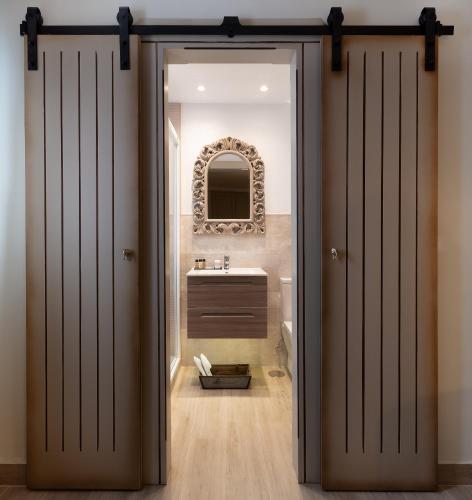 an open door leading to a bathroom with a sink at Hostal Boutique Plaza Cantarero in Nerja