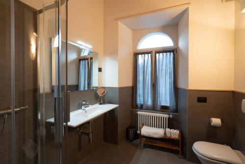 a bathroom with a sink and a toilet and a window at Marzia Lounge in Bormio