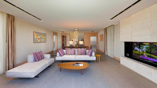 a living room with two couches and a tv at Sirene Luxury Hotel Bodrum in Yalıkavak
