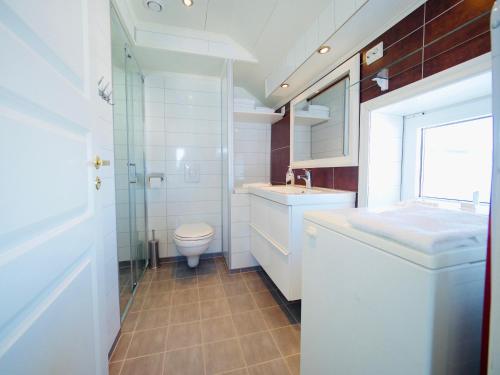 uma casa de banho branca com um WC e um lavatório em Lofoten Ocean View - Sandøy Gård em Sand