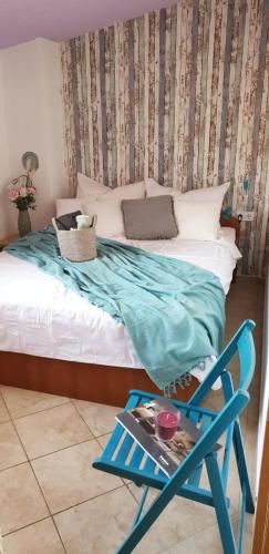 a bedroom with a bed with a blue chair next to it at Apartment Ivica in Vir