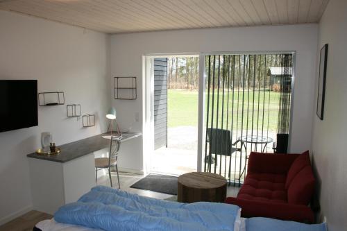 a living room with a couch and a sliding glass door at Silkeborg Sø Camping Apartments in Silkeborg