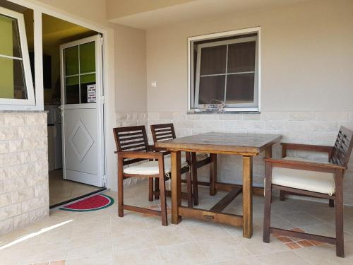 uma mesa e cadeiras num quarto com uma cozinha em Apartment Ivica em Vir