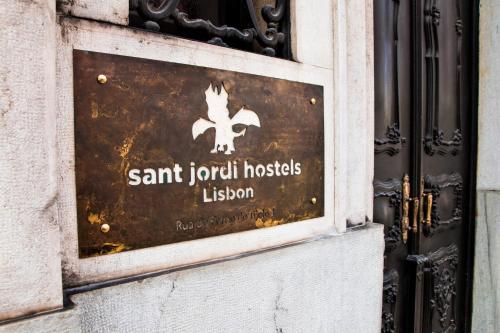 a sign on the door of a building at Sant Jordi Hostels Lisbon in Lisbon
