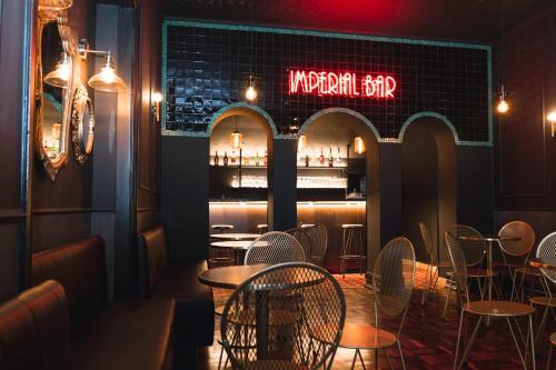 a restaurant with tables and chairs and a bar at Sant Jordi Hostels Lisbon in Lisbon