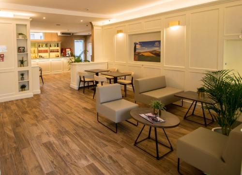 a waiting room with tables and chairs at Hotel Perlage Florence - Free city tax with Private Parking & Fast Wifi in Scandicci