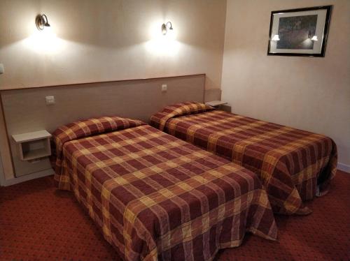 a hotel room with two beds in a room at Logis Hotel Calisola Besançon - Soirée Etape in Chalezeule