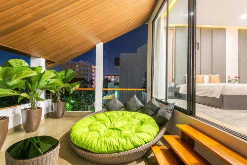 Khong Cam Garden Villas في هوي ان: غرفة مع مسند أخضر على شرفة