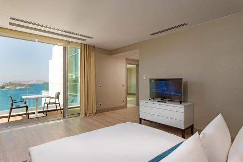 a bedroom with a bed and a flat screen tv at Sirene Luxury Hotel Bodrum in Yalıkavak