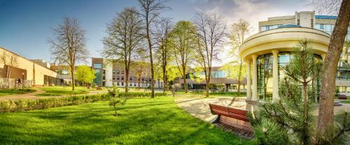 a park with a bench in front of a building at Grand SPA Lietuva Hotel Lietuva in Druskininkai