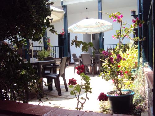 a patio with a table and chairs and flowers at Hotel Hacienda El Aserrio in Iza