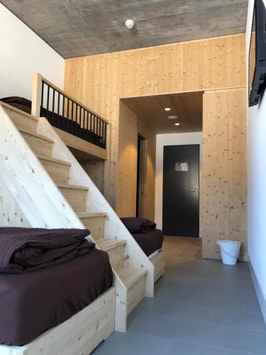 - une chambre avec 2 lits, un escalier et une porte dans l'établissement Catrina Hostel, à Disentis