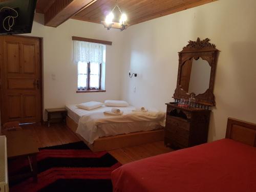 a bedroom with a bed and a mirror and a window at Kalliopi in Papingo