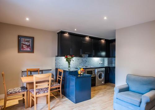a kitchen and living room with a table and chairs at Molesworthcourt Suites in Dublin