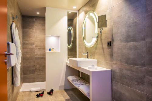 a bathroom with a sink and a mirror at Radisson Blu Hotel Bordeaux in Bordeaux
