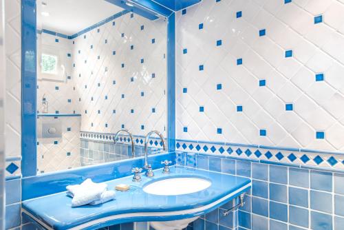 Un baño azul con lavabo y espejo. en Orangerie St Paul, en Saint-Paul-de-Vence