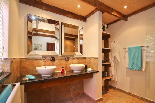 ein Badezimmer mit 2 Waschbecken und einem Spiegel in der Unterkunft Montrose Guesthouse in Somerset West