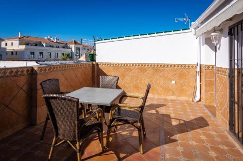 a patio with a table and chairs on a balcony at Hostal Luna de Nerja in Nerja