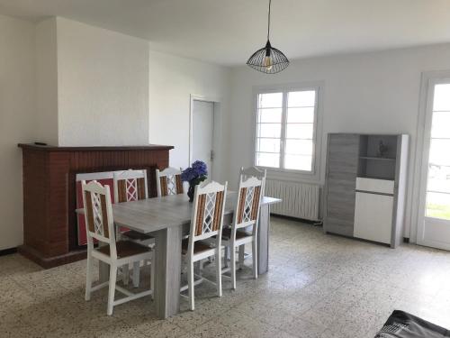 - une cuisine avec une table à manger et des chaises dans l'établissement BISCA MAISON FAMILIALE LANDAISE, à Biscarrosse