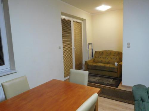 a living room with a table and a couch at Wynajem pokoi Białystok in Białystok