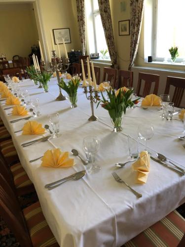 een lange tafel met een witte tafeldoek en gele servetten bij Hotel Pension Gutshaus Neu Wendorf in Sanitz