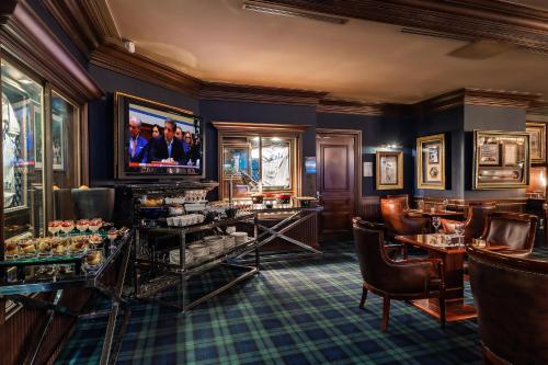 a restaurant with a bar with chairs and a television at Kensington Hotel Yeouido in Seoul