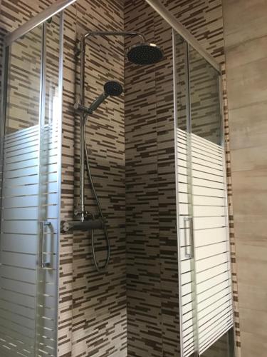 a shower in a bathroom with two windows at Sirios in Acharavi