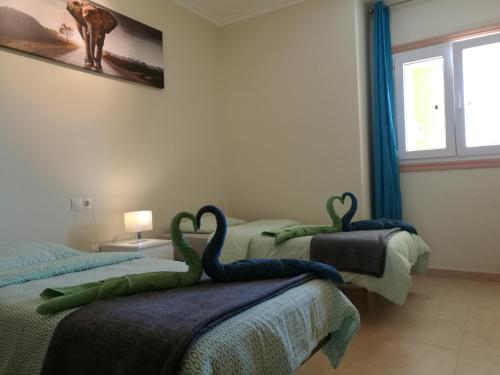 two beds in a room with swans on them at Vida Cotillo - No Stress Holidays in El Cotillo