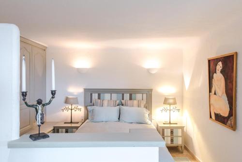 a white bedroom with a bed and two lamps at Orangerie St Paul in Saint-Paul-de-Vence