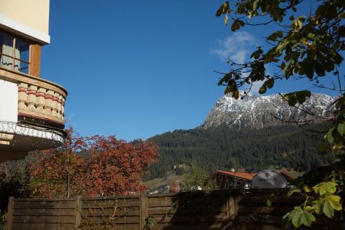 a view of a mountain with a house and a fence at Das Traditionshotel Schwarzer Adler in Tannheim