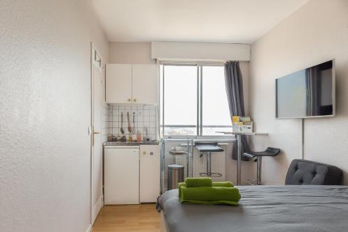 une chambre avec un lit et une cuisine avec une fenêtre dans l'établissement Travel Homes - Le Wilson, face à la gare, à Mulhouse