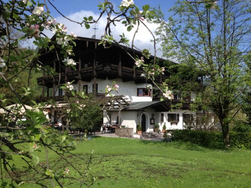 ein großes weißes Haus mit Bäumen davor in der Unterkunft Alpenhof Landhotel Restaurant in Oberaudorf
