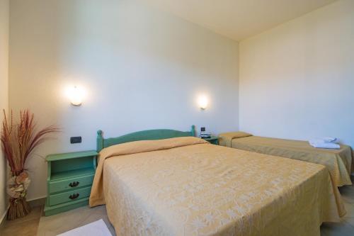 a bedroom with two beds and a green dresser at Albergo Residenziale Gli Ontani in Cala Liberotto