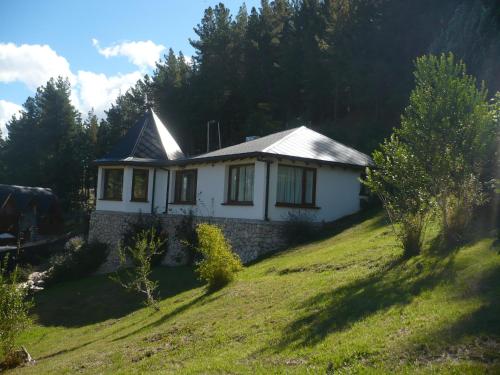 a small house on top of a grassy hill at Altos de Esquel in Esquel