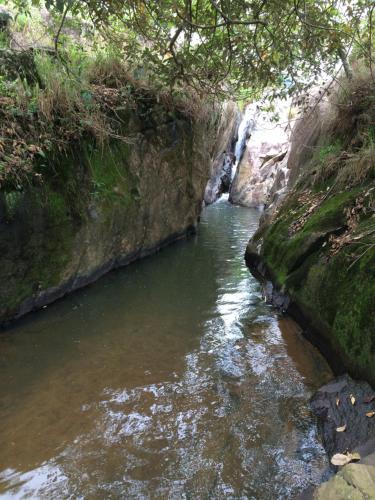 a river with a waterfall in a rocky area at Aconchego e conforto em Joanópolis in Joanópolis