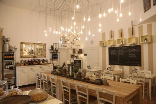 - une salle à manger avec une table, des chaises et des lumières dans l'établissement Palazzo Bignami, à Lecce