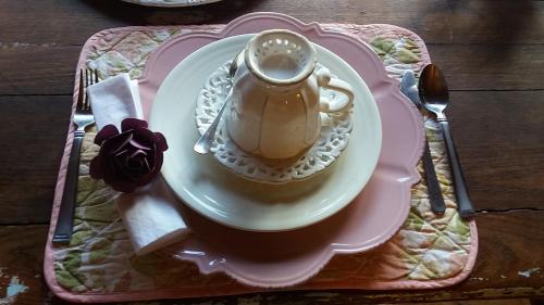 a cup of coffee on a plate on a table at Pousada Off Road A Casa da Montanha in Delfim Moreira