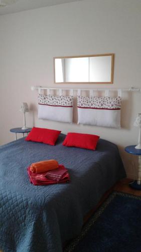 - une chambre avec un lit et 2 oreillers rouges dans l'établissement Le Faidherbe, à Albert