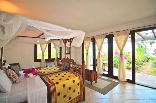 een slaapkamer met een hemelbed bij Villa Paradise on the Ocean in Gazija