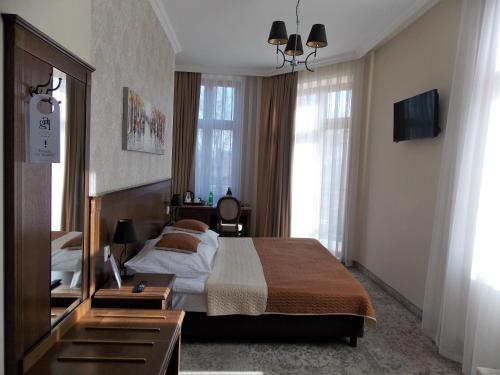 a hotel room with a bed and a mirror at Hotel Gal in Tarnów