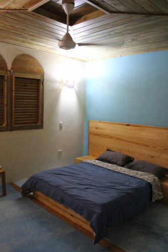 Schlafzimmer mit einem großen Bett mit einem Kopfteil aus Holz in der Unterkunft La Casa Del Arbol in Las Galeras