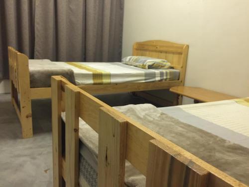 a room with two bunk beds and two tables at Little Cozy Homestay in Kota Bharu