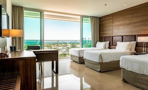 Pokój hotelowy z 2 łóżkami i biurkiem w obiekcie Américas Barra Hotel w mieście Rio de Janeiro
