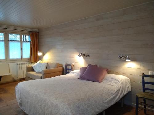 ein Schlafzimmer mit einem Bett, einem Sofa und einem Stuhl in der Unterkunft Hostal D'Éller in Éller